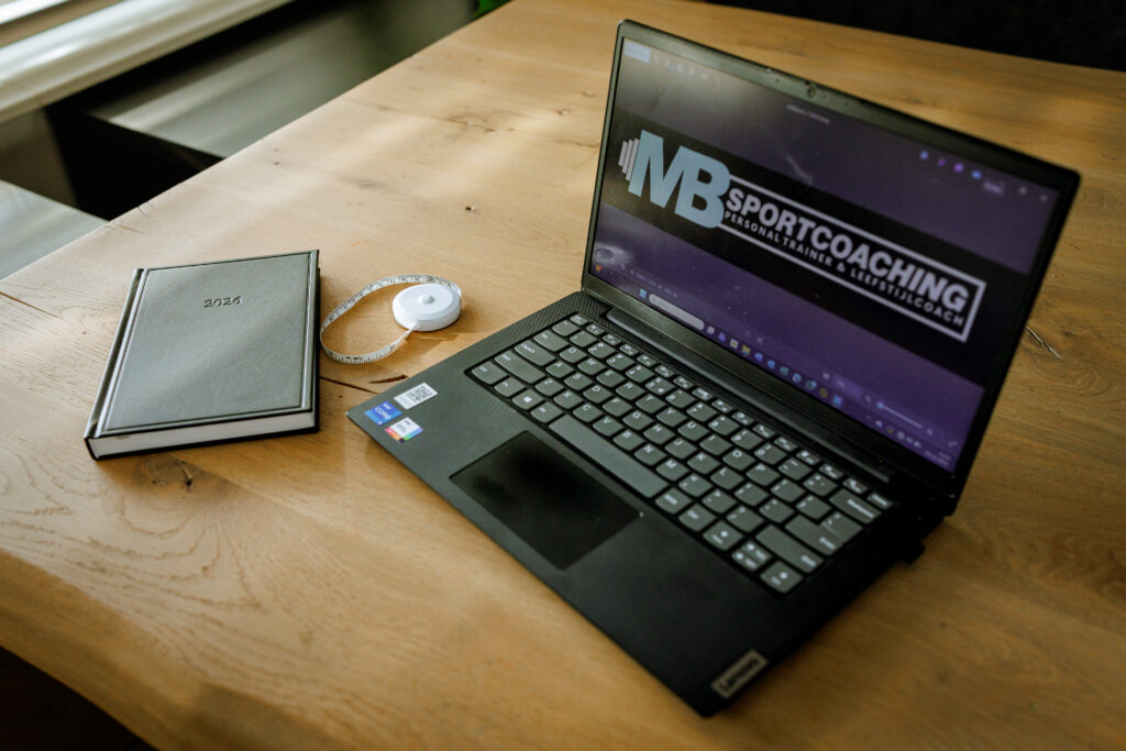 Laptop en meetlint als symbool voor online coaching, training en voortgang